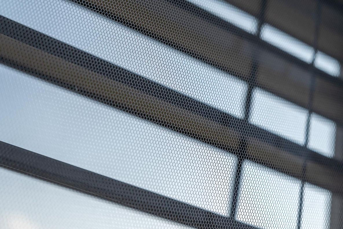 Nahaufnahme eines feinmaschigen Insektenschutzgitters vor einem Fenster
